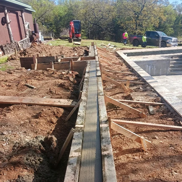 Pouring a residential concrete Tulsa foundation footer next to a pool