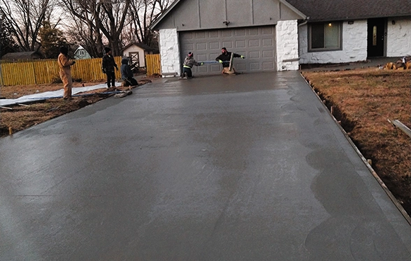 Tulsa residential concrete crew pouring a new driveway in front of a garage